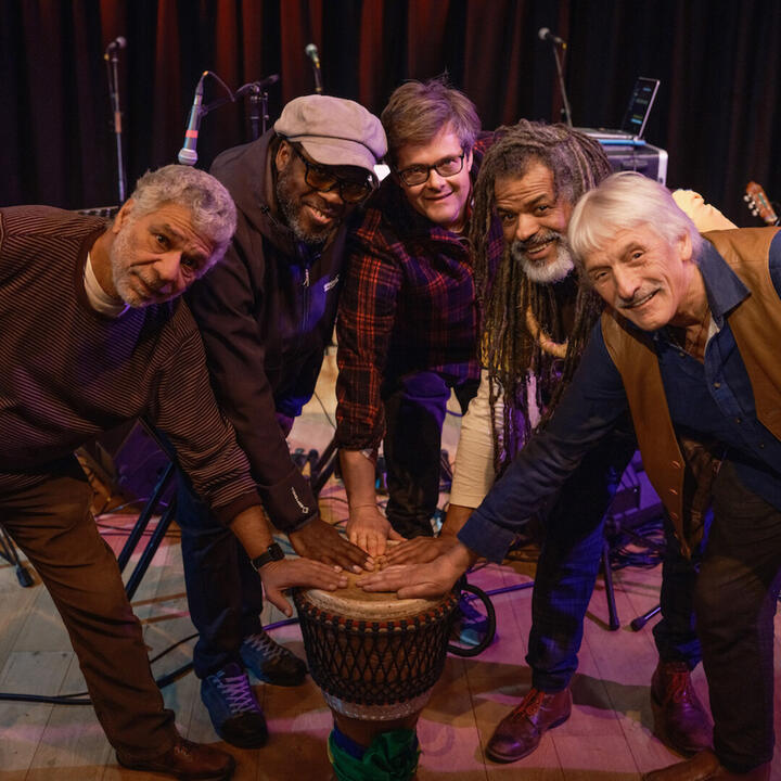 5 mannen met hun hand op een djembe