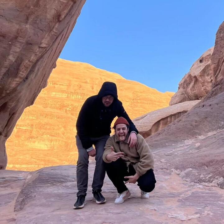 2 mannen in spectaculair landschap met rotsen, woestijn en blauwe lucht