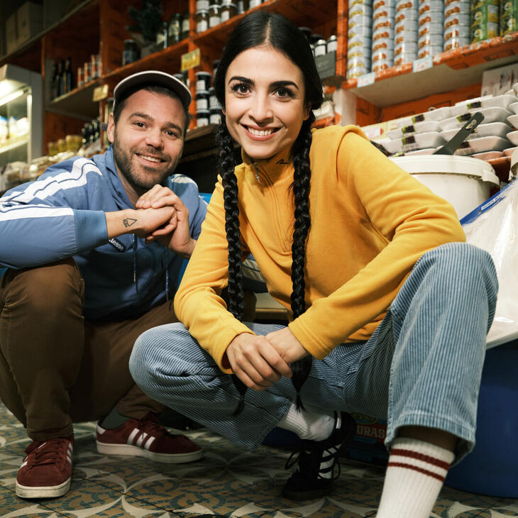 Jacqueline Baghdasaryan en Louis Thomas zitten gehurkt op de grond en kijjken richten de camera met een serieuze blik.